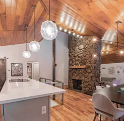 The carpeted conversation pit in front of the fireplace had a groovy vibe, but ultimately the homeowners removed it to improve flow in the open living area. - ERICK DOXEY PHOTO