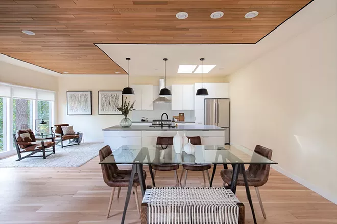 A small kitchen, hidden behind a partial wall, felt isolated from the home's gathering areas. Removing the wall allowed the addition of much needed storage in the new kitchen's double-sided nine-foot island. Pendant lights delineate the space. - KAYLEEN GILL PHOTO
