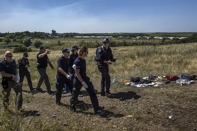 An international team of experts at the crash site of Malaysia Airlines Flight 17 in Grabovo, Ukraine, on Aug. 1, 2014. International prosecutors on Wednesday, June 19, 2019, said that four men, including three with close ties to the Russian military and intelligence, would face murder charges in the downing of the passenger jet five years ago, killing 298 people. - MAURICIO LIMA/THE NEW YORK TIMES