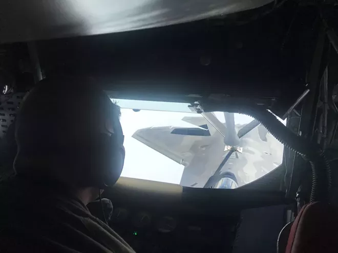 Boom operator Devin Battle, an airman at Fairchild AFB, works as a KC-135 attaches to a Raptor for refueling in mid-air. - RILEY UTLEY PHOTO