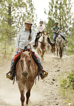 True West Trail Rides co-owner Shawn Anderson, helps 7-year-old Jude Thompson onto Cricket. - YOUNG KWAK PHOTO