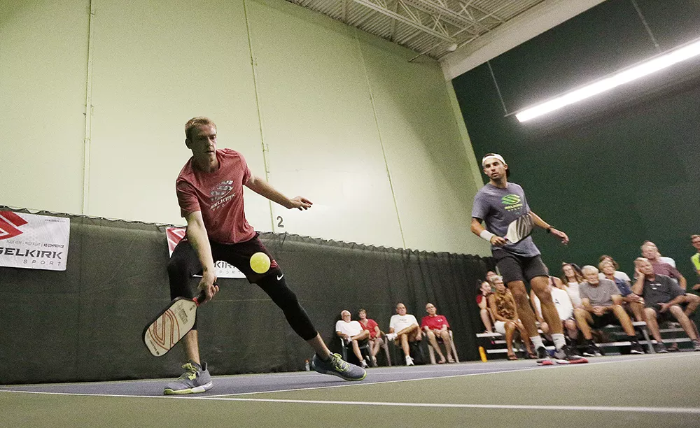 Matt Goebel, left, hits the ball as teammate Tyson McGuffin looks on, during a doubles exhibition match at the North Park Athletic Club. - YOUNG KWAK PHOTO