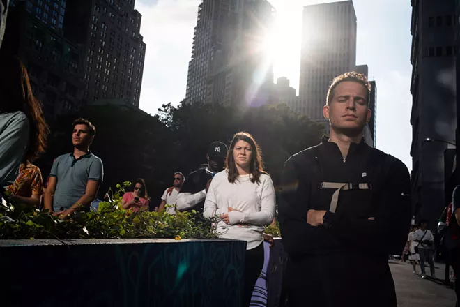 Passersby stop to observe a moment of silence on Dey Street, near the 9/11 Memorial in lower Manhattan, on Thursday, Sept. 11, 2019, the 18th anniversary of the Sept. 11 terror attacks. - TODD HEISLER/THE NEW YORK TIMES