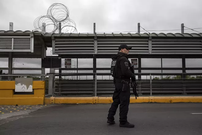 A Customs and Border Protection agent on a bridge between Mexico and Hidalgo, Texas, Nov. 9, 2018. - TAMIR KALIFA/THE NEW YORK TIMES