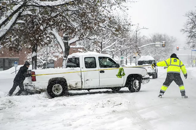 Men work to remove a truck from a snow drift in Boulder, Colo., Nov. 26, 2019. A powerful storm is cutting across the country from Colorado to the Great Lakes, disrupting flights and dumping snow. - CHET STRANGE/THE NEW YORK TIMES