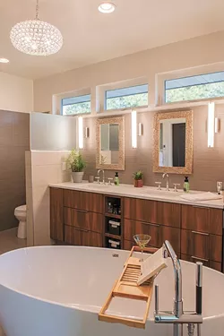 A soaking tub with views of the treetops lends a "zen" quality to Debbi Bravo's favorite room in her home, the master bath, while the crystal light fixture adds an unexpected sparkle. - ERICK DOXEY PHOTO