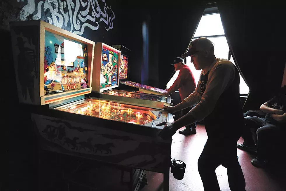 Marcus Schmick (left) and Bryce Rich play during a recent tournament for Berserk's pinball league. - YOUNG KWAK PHOTO