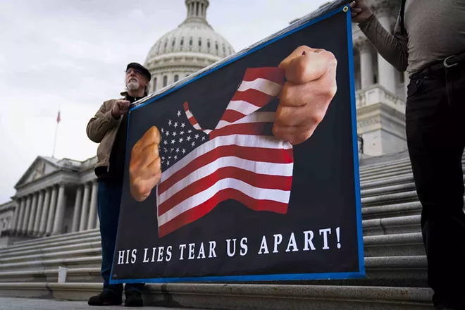 Protester stand outside the Capitol in Washington on Tuesday, Feb 4, 2020. After spending nearly two weeks confined to their desks and forbidden from speaking, senators took turns on the Senate floor on Tuesday announcing whether they planned to vote to convict or acquit President Donald Trump when they render a verdict on Wednesday in the third presidential impeachment trial in the nation’s history. - DOUG MILLS/THE NEW YORK TIMES