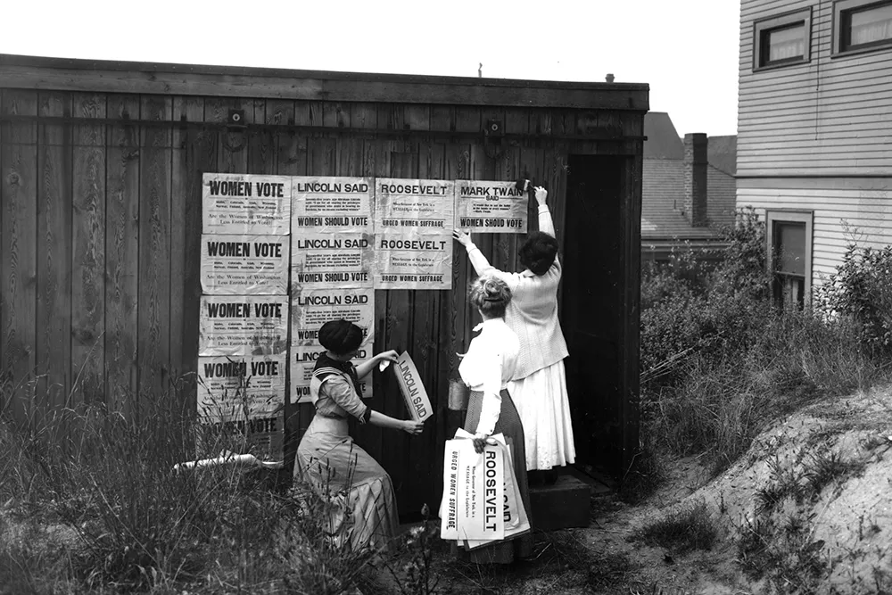 Three women from the Washington Equal Suffrage Association post signs in 1910. - PHOTO BY ASAHEL CURTIS FROM GENERAL SUBJECTS PHOTGRAPH COLLECTION OF THE WASHINGTON STATE ARCHIVES