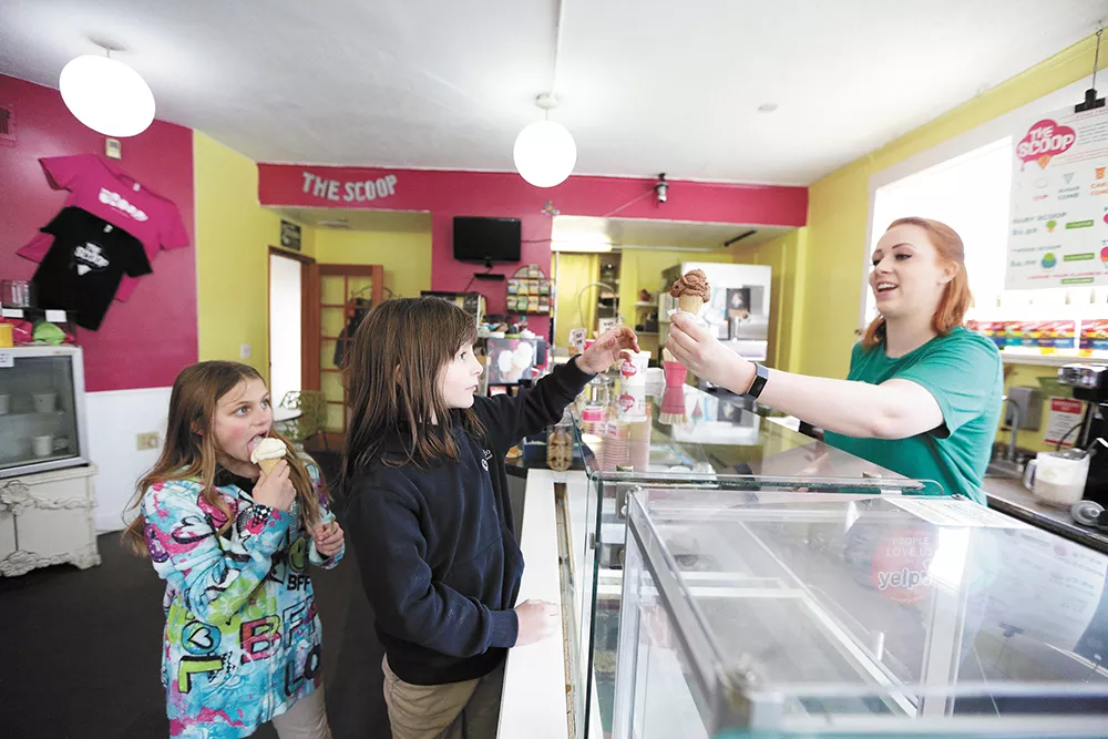 Pennelope, left, eats lemon cake ice cream as her sister, Brooklyn, orders from Scooperista Jordan Shook at the Scoop. - YOUNG KWAK PHOTO