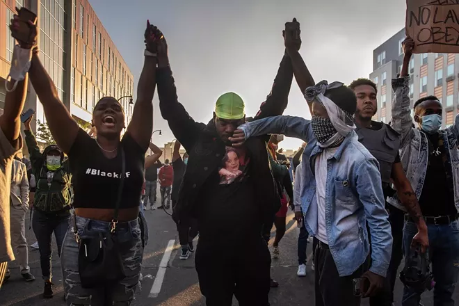A protester wipes a tear from another as they demonstrate against the death of George Floyd, a black man killed in police custody, in Minneapolis, May 29, 2020. Minneapolis residents said outrage and protests in the aftermath of the killing of George Floyd were a result of a community being tested repeatedly in recent weeks by both police violence and the virus — and in ways that put America’s deep racial inequalities in stark relief. - VICTOR J. BLUE/THE NEW YORK TIMES