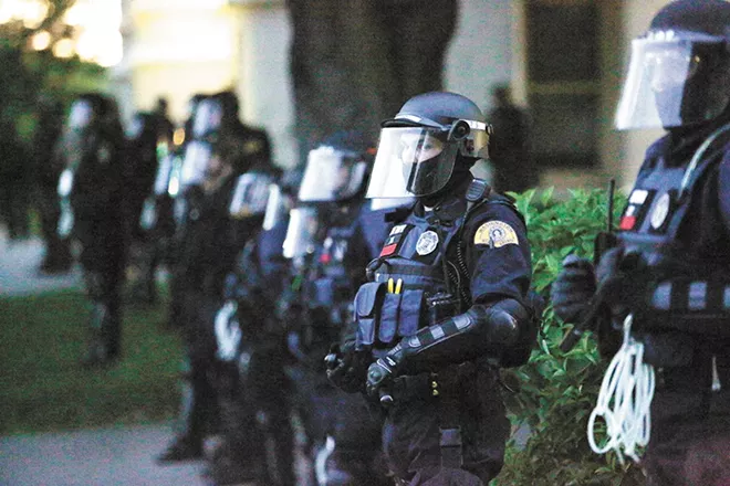 Law enforcement officers in tactical gear during Sunday's peaceful protest outside the Spokane County Courthouse. - YOUNG KWAK PHOTO