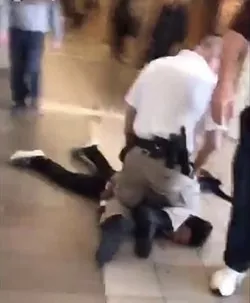 Former school resource officer Shawn Audie pinning down a black Ferris High School student last January.
