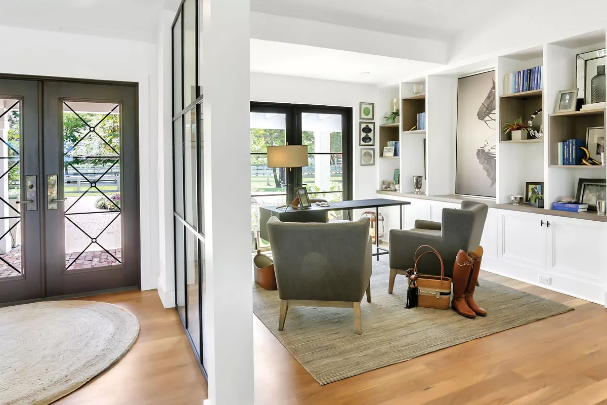 With expansive windows providing views to the stables, this office for a professional equestrian team owner incorporates built-ins to hide office-related equipment, freeing up shelf space for more interesting displays. - PHOTO COURTESY OF DESIGN FOR THE PPL