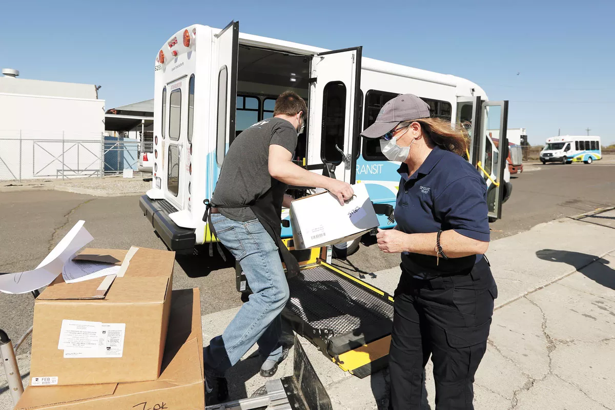 Greater Spokane County Meals on Wheels Kitchen Supervisor Kristopher Elliott-Klemz, left, and STA Paratransit Driver Suzy Paden load frozen meals for delivery. - YOUNG KWAK PHOTO