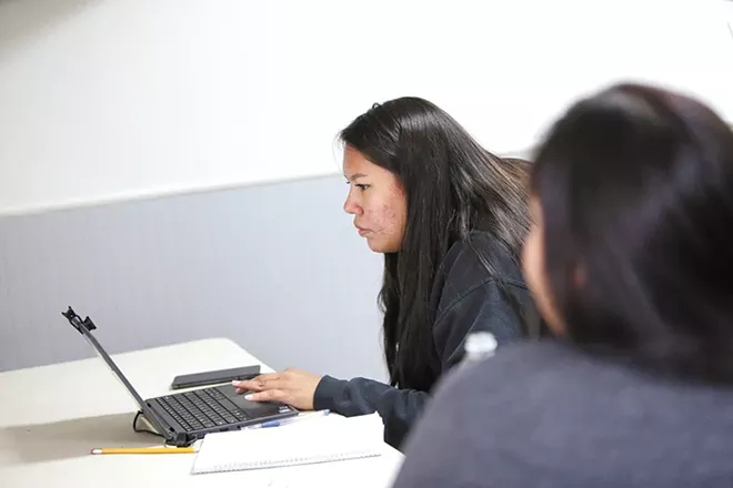 From Open Doors Family Shelter, Lewis and Clark High School junior Simone LaDue, left, takes a Native American literature class remotely as her mother, Angela Pepion, looks on. - YOUNG KWAK PHOTO