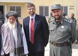 Michael Baumgartner (center) before he was a state senator, flanked by an Afghan elder and police officer. - COURTESY OF ELEANOR BAUMGARTNER
