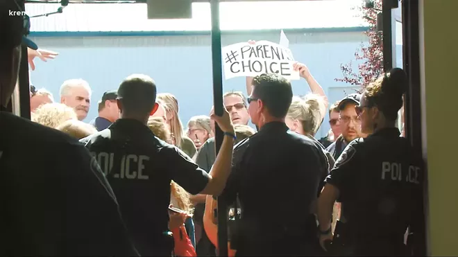Police in Coeur d'Alene had to block a throng of angry protesters from a school board meeting last month. - COURTESY OF KREM