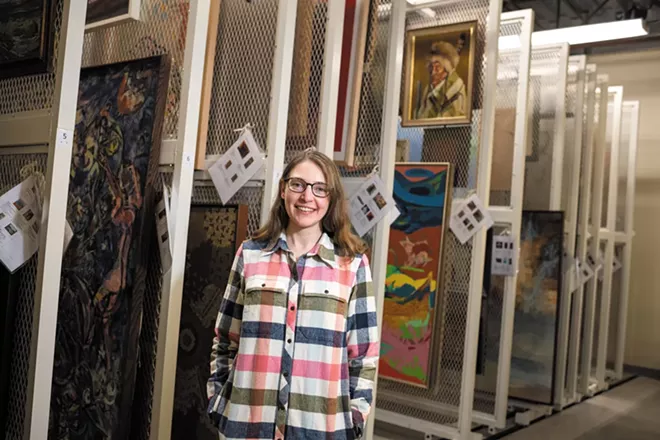 In the vault in Gonzaga's Jundt Museum, Britta Keller Arendt stands near rows of hanging racks storing art that's not on display to the public. - ERICK DOXEY