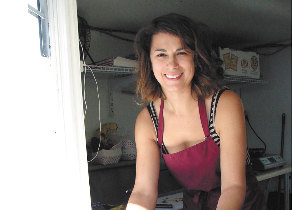 Amie Wolf in her Baconapolis food cart in Sandpoint. - CARRIE SCOZZARO