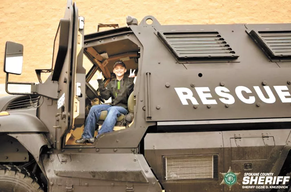 At December's Holidays and Heroes event, a boy sits in an MRAP vehicle some local critics see as police militarization.