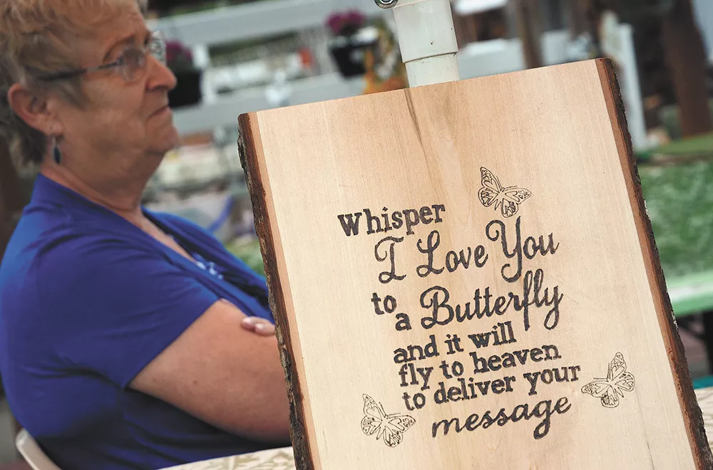 Karen Webber with a sign that was made for the family following Scotty's death, highlighting the significance of butterflies in their house. - MIKE SALSBURY