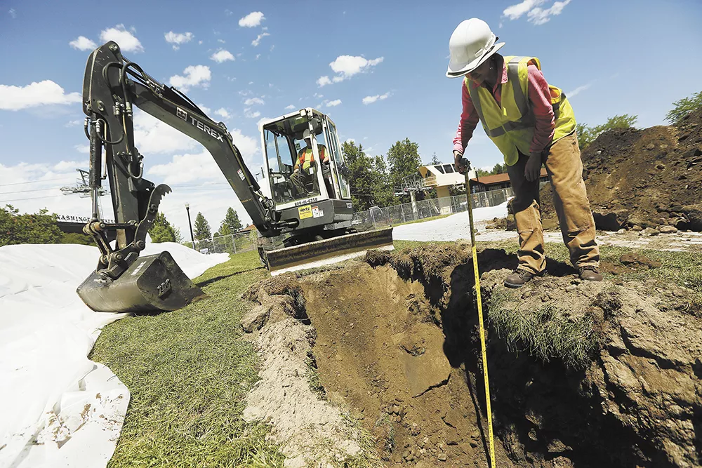 Fort Walla Walla Museum archaeologist Ashley Morton inspects a trench in Riverfront Park's Gondola Meadow, which was once a prominent area for the Spokane Tribe before becoming an early part of downtown Spokane. - YOUNG KWAK