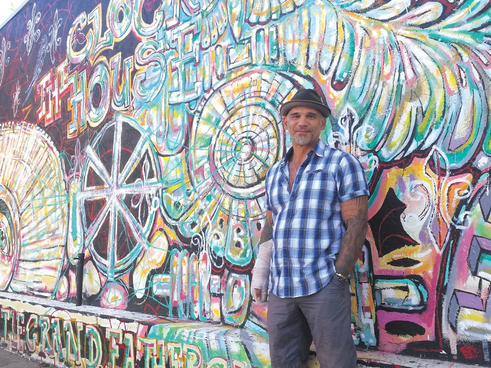 Muralist Nate O'Neill, with his work at the Clock House, sees North Hill as an arts haven. - DAN NAILEN