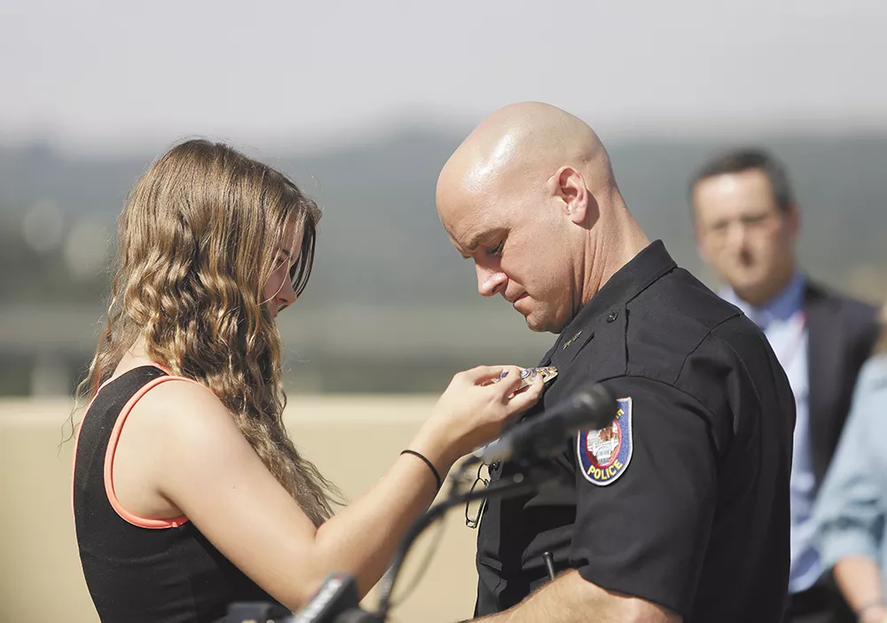 Craig Meidl's daughter, Emma, pins the chief's badge on her dad following the announcement of his nomination last week. - YOUNG KWAK