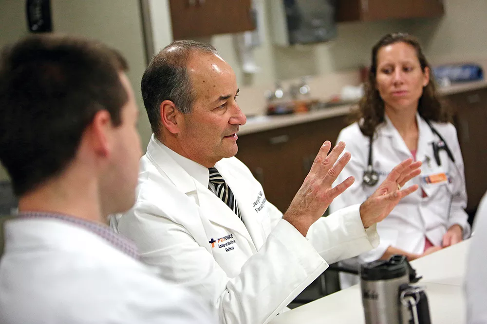 Dr. Darryl Potyk leads a discussion about the music of Neil Young prior to setting out on rounds with residents, attending physicians and students (including Pamela Schultz, pictured), at Providence Sacred Heart. - YOUNG KWAK