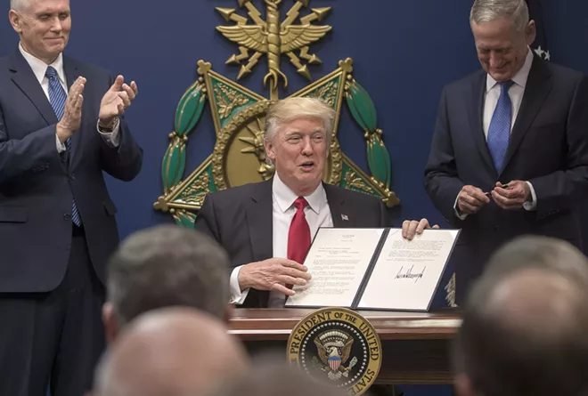 President Donald Trump holds up an executive order he signed at the Pentagon, where James Mattis, right, was also sworn in as defense secretary, in Arlington, Va., Jan. 27, 2017. Trump signed orders related to military spending and the vetting of immigrants. At left is Vice President Mike Pence. - STEPHEN CROWLEY/THE NEW YORK TIMES