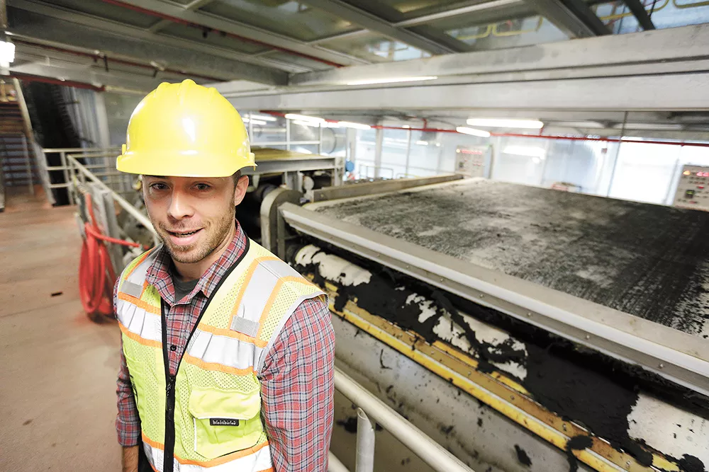 Kyle Arrington, a chemist with Spokane Wastewater Management, shows the press that removes excess water from biosolids. - YOUNG KWAK