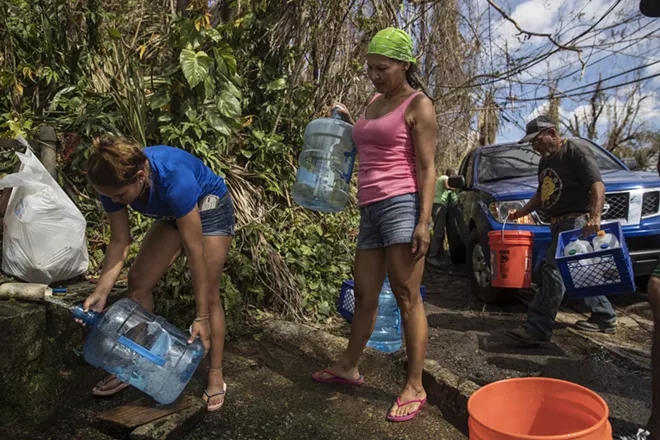 Luz Rosado, center, directs the filling of water vessels at a natural spring at her home in Toa Alta, Puerto Rico, Sept. 25, 2017. The Trump administration, which has insisted that its efforts in Puerto Rico were adequate, faced increasing pressure on Sept. 28 to mount a more aggressive response to Hurricane Maria’s devastating lashing of the island. - VICTOR J. BLUE/THE NEW YORK TIMES