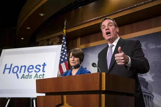 Sen. Mark Warner (D-Va.), joined by Sen. Amy Klobuchar (D-Minn.), talks about online political ads and preventing foreign interference in elections at a news conference on Capitol Hill in Washington, Oct. 19, 2017. Russian agents disseminated inflammatory posts that reached 126 million users on Facebook while uploading more than 1,000 videos to Google’s YouTube service, according to two people familiar with the matter. - AL DRAGO/THE NEW YORK TIMES
