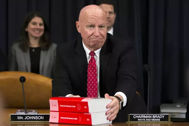 Rep. Kevin Brady (R-Texas), chairman of the House Ways and Means Committee, places Internal Revenue Code books along the bar before the Republican tax reform bill markup on Capitol Hill in Washington, Nov. 6, 2017. The committee is considering and amending the bill, with the goal of passing it out to the House floor by the end of the week. - TOM BRENNER/THE NEW YORK TIMES)