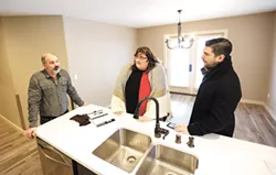Project Managers Colt Utley and Jacob Pollowitz (left, right) stand with service provider Rachell Redman in the kitchen of a newly remodeled "health home." - YOUNG KWAK