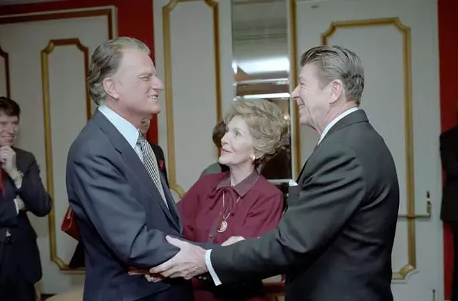 President Ronald Reagan and first lady Nancy Reagan greet Graham at the National Prayer Breakfast of 1981. - WHITE HOUSE PHOTO