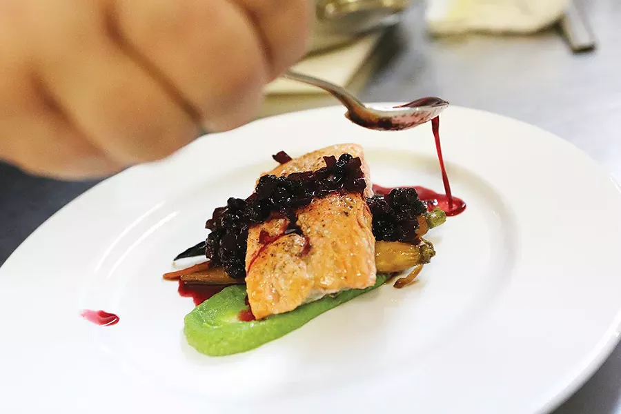 Chef Jennifer Parkinson carefully plates salmon with huckleberry chutney. - YOUNG KWAK