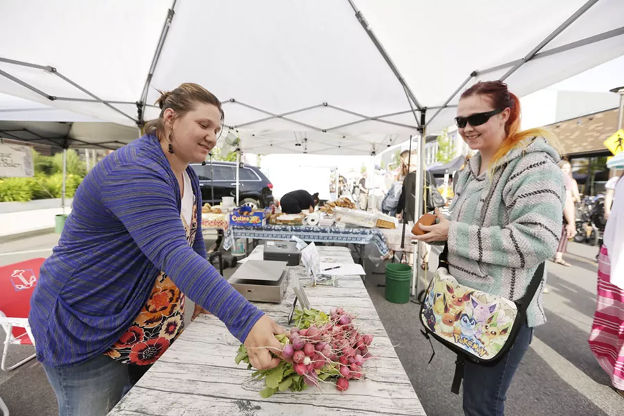 Red Beard co-owner Jessica Kaluza sells radishes to a customer in Kendall Yards. - YOUNG KWAK