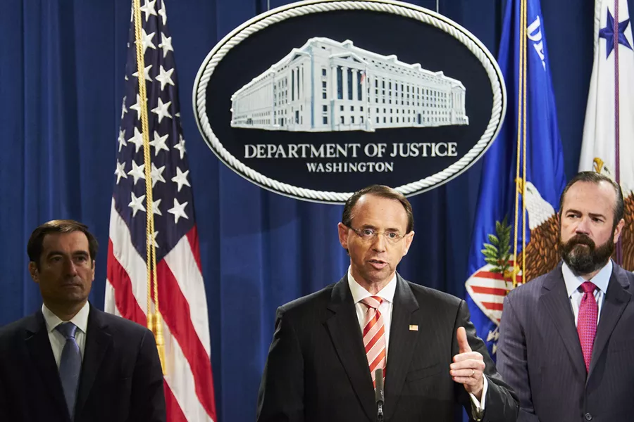 Deputy Attorney General Rod Rosenstein, center, at a news conference at the Justice Department in Washington, July 13, 2018. Rosenstein on Friday announced new charges against 12 Russian intelligence officers accused of hacking the Democratic National Committee and the Clinton presidential campaign. The announcement came just a few days before President Donald Trump is expected to meet with President Vladimir Putin of Russia in Finland. - T.J. KIRKPATRICK/THE NEW YORK TIMES