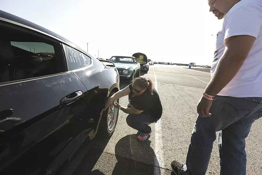 Shelly Walsh checks the tire pressure on her 2018 Ford Mustang GT. - YOUNG KWAK