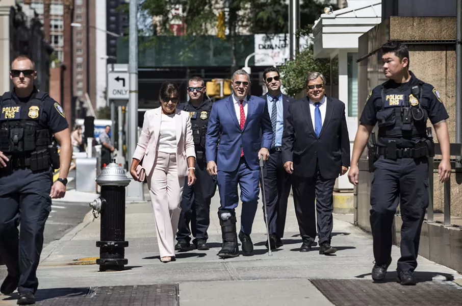 Amalija and Viktor Knavs, parents of first lady Melania Trump, walk with their attorney Michael Wildes, center with cane, and a police escort to the ceremony where they will become naturalized U.S. citizens at the Jacob K. Javits Federal Building in Manhattan, Aug. 9, 2018. - HOLLY PICKETT/THE NEW YORK TIMES