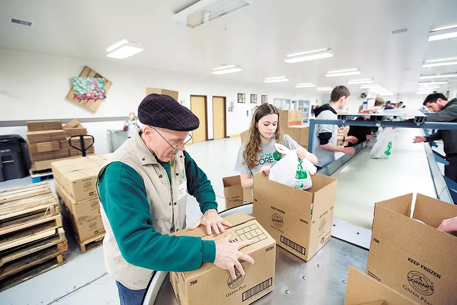 Volunteers assemble meal kits at Second Harvest. - YOUNG KWAK