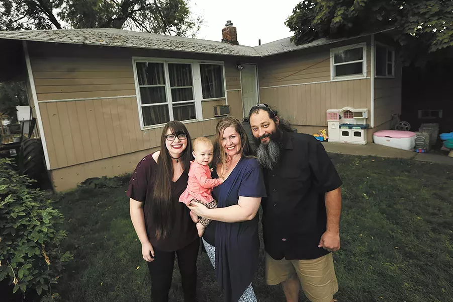 FROM RIGHT: William and Autumn Nixdorf, with daughters Avalynn (1) and Haley (17) in front of the home they saved from foreclosure. - YOUNG KWAK