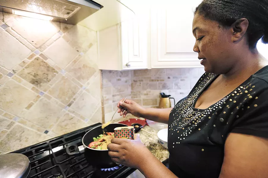 Kenyan native Jane Kamuasi prepares traditional mbuzi, a goat-based dish. - YOUNG KWAK