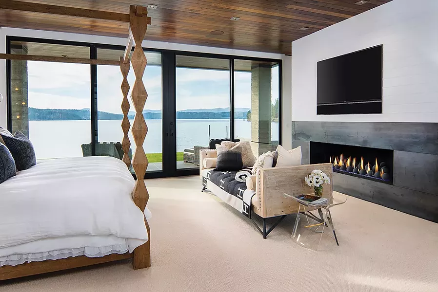 A dramatic fireplace complements expansive water views in this Coeur d'Alene master suite. - JOEL RINER PHOTO