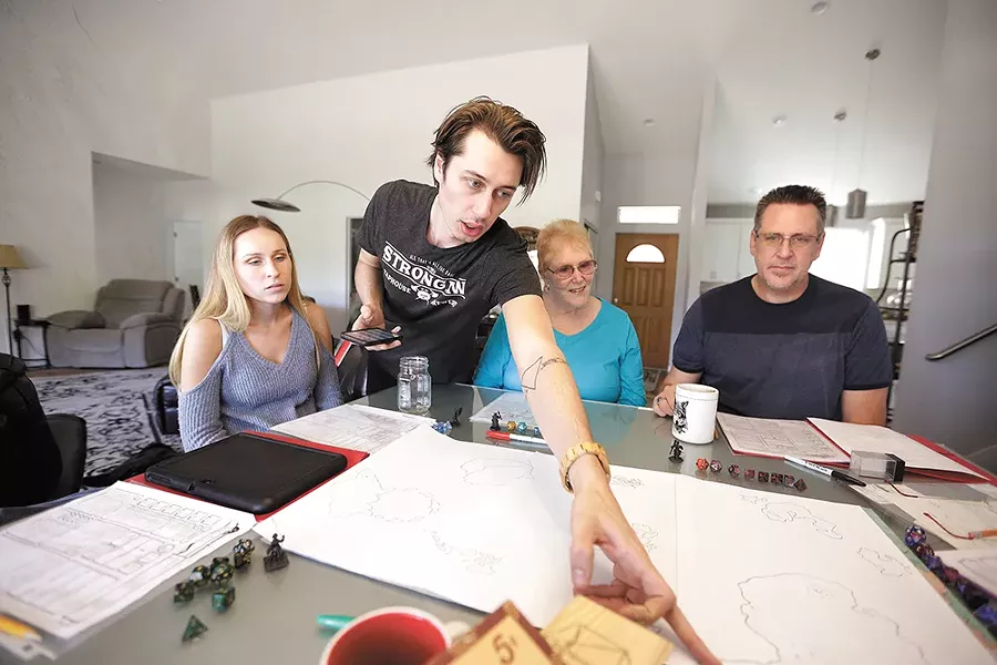 Dungeon master Josh Adrian, second from left, points out a spot on the game map to his sister Kayla (far left), grandmother Reggie Adrian and dad Joel Adrian. - YOUNG KWAK