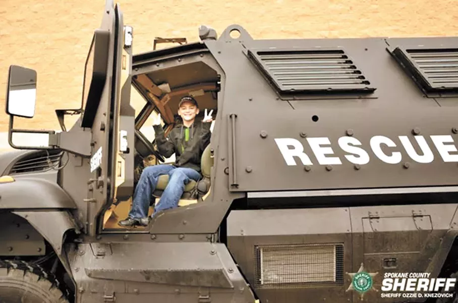 At December's Holidays and Heroes event, a boy sits in an MRAP vehicle some local critics see as police militarization.