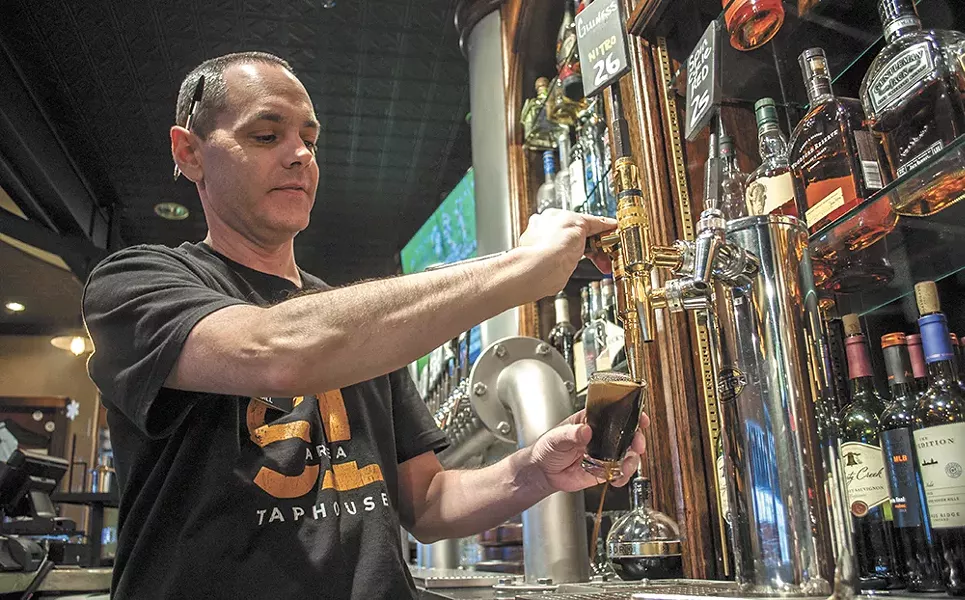 Bill Matthew pours a sample of River City Brewing's Vanilla Burbon Stout at the Area 51 Taphouse. - SARAH WURTZ