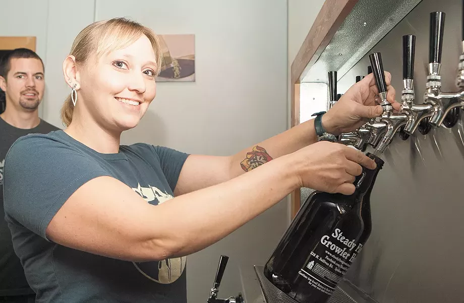 Co-owner Cassaundra Preston pours from one of the 39 taps at Steady Flow Growler House. - MEGHAN KIRK